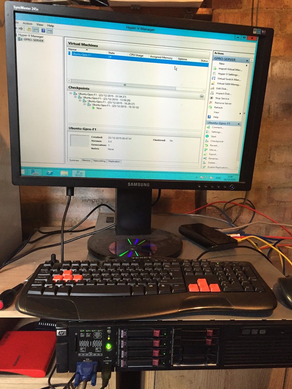 Monitor showing Hyper-V Manager with an Ubuntu VM, server beneath the keyboard
