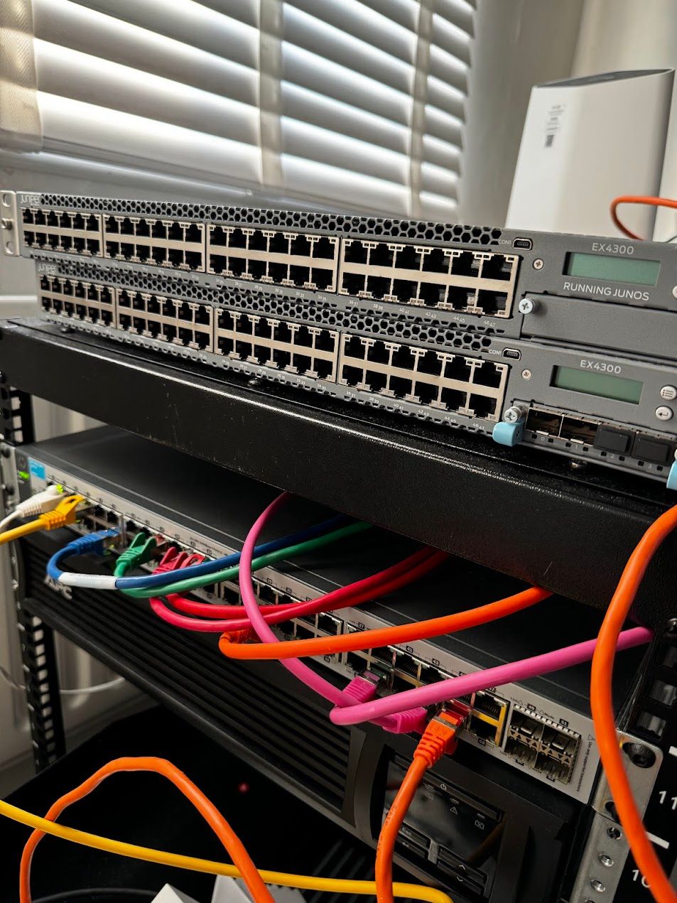 Two stacked network switches above a fully cabled panel